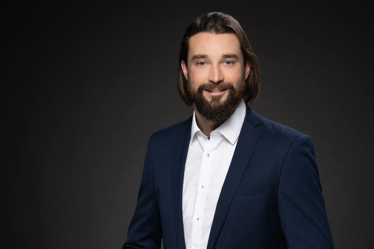Professionelle Bewerbungsbilder: junger Mann im Business-Look mit neutralem Hintergrund, seriöser und selbstbewusster Ausdruck.