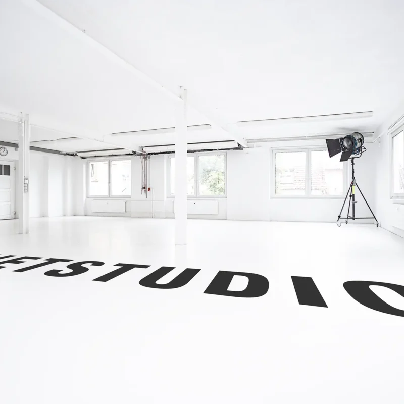 Helles, komplett weißes Tageslichtstudio mit großen Fenstern und flexiblen Hintergrundsystemen