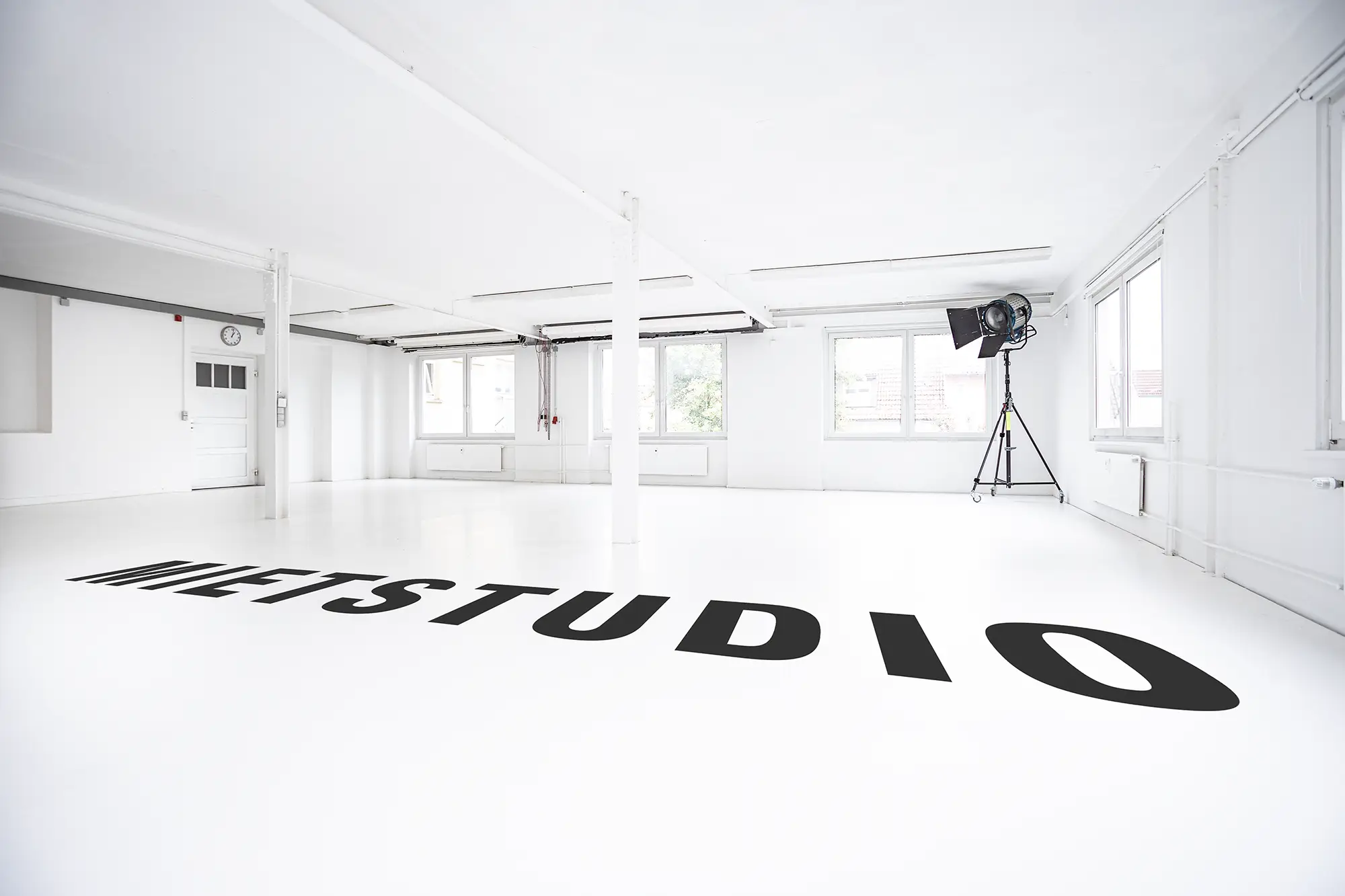 Helles, komplett weißes Tageslichtstudio mit großen Fenstern und flexiblen Hintergrundsystemen