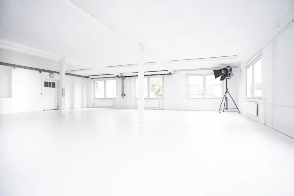 Helles, komplett weißes Tageslicht Mietstudio mit großen Fenstern und flexiblen Hintergrundsystemen